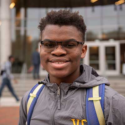 a smiling v.c.u. student standing near cabell library