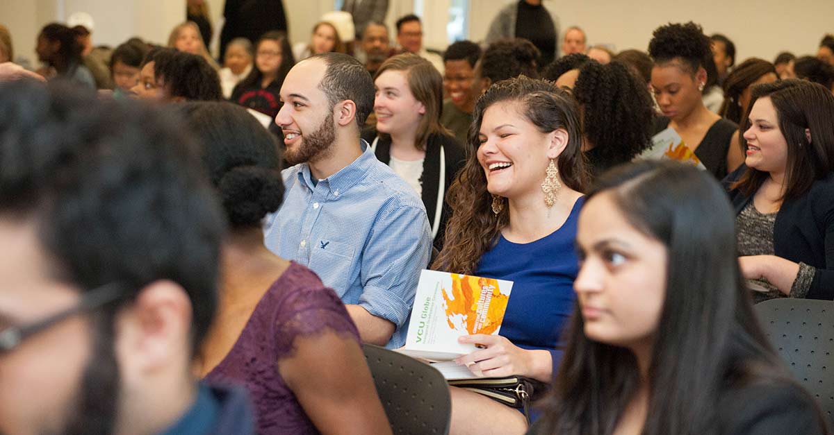 A seated audience laughing during an lecture event.