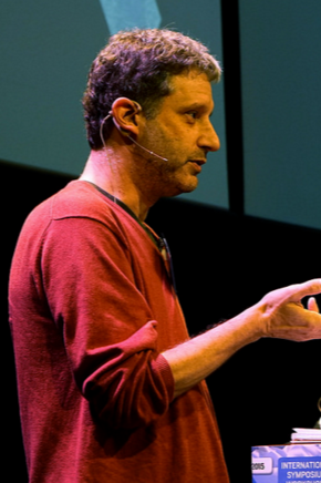 Professor David Golumbia lecturing in a red shirt